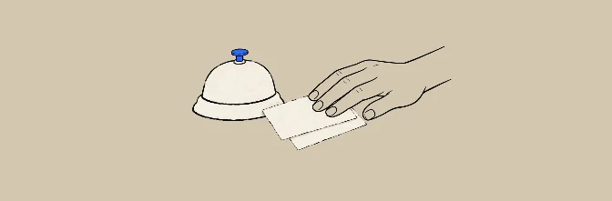 Una campanilla de recepción y una mano que entrega una tarjeta